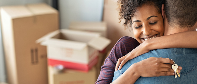 man and woman hugging while unpacking