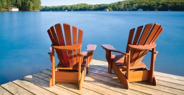 two wooden chairs on a dock