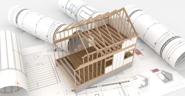 frame of house with blueprints
