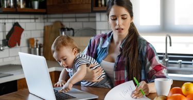 woman working while holding baby