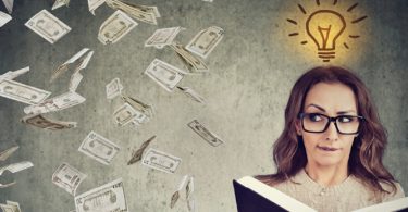 woman reading book with money