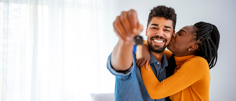 man and woman embracing holding keys