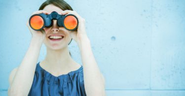 woman looking through binocculars