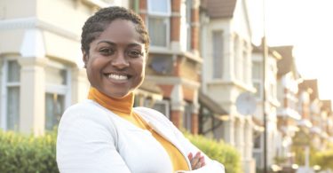 woman posing in front of real estate
