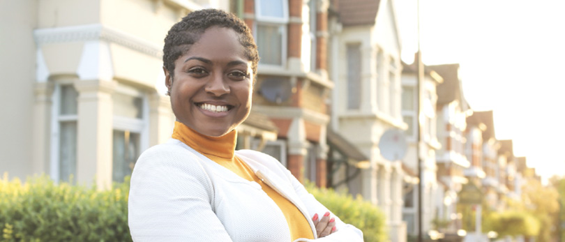 woman posing in front of real estate