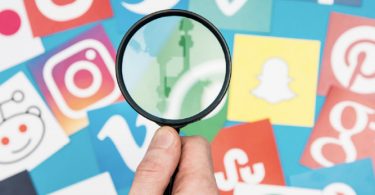 magnifying glass looking at social media icons