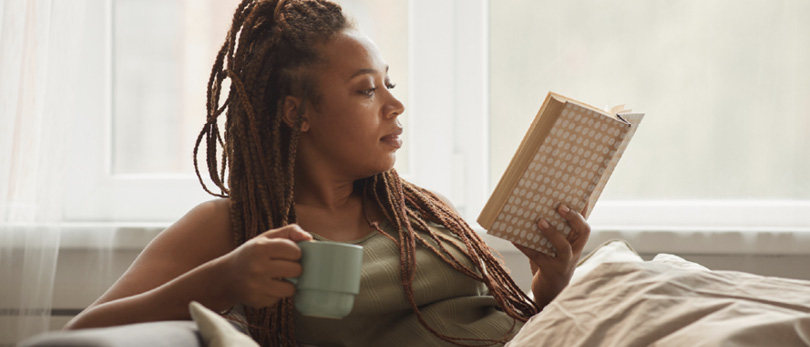 woman reading book with coffee