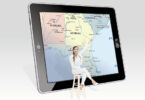 woman sitting in front of map on tablet