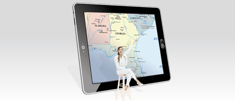 woman sitting in front of map on tablet