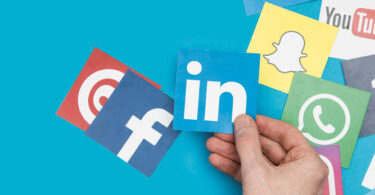 social media icons with LinkedIn held by hand