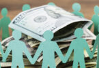 paper dolls holding hands around pile of money