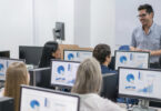 man teaching class involving computers