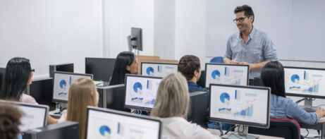 man teaching class involving computers