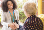 an agent greeting a woman at her home