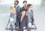 group of business professionals standing behind queue rope
