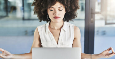 woman practicing mindfulness in front of computer