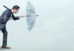 man fighting wind with umbrella