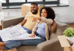 couple on couch looking at blueprints