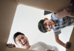 father and son looking into box