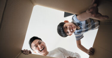 father and son looking into box