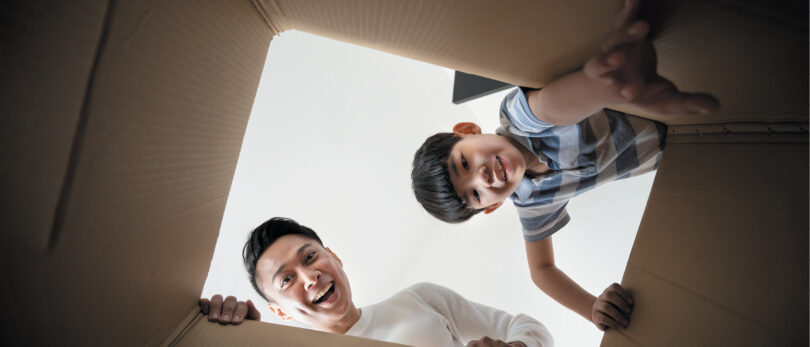 father and son looking into box