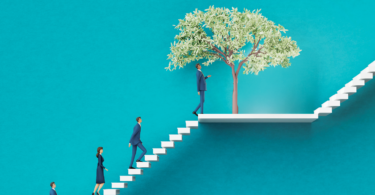 People walking up a white staircase with a tree on a landing in the middle