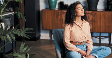 Woman meditating in her living room