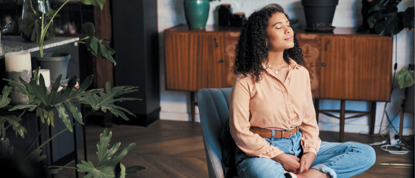 Woman meditating in her living room