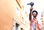 Man with a selfie-stick taking a video in the street