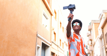 Man with a selfie-stick taking a video in the street