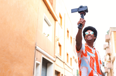 Man with a selfie-stick taking a video in the street