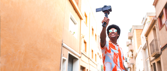 Man with a selfie-stick taking a video in the street